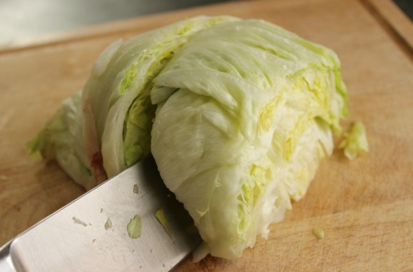 Cutting a wedge off a head of iceberg lettuce Cutting an Iceberg lettuce wedge