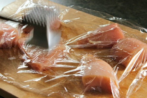 preparing chicken with meat tenderizer for skillet