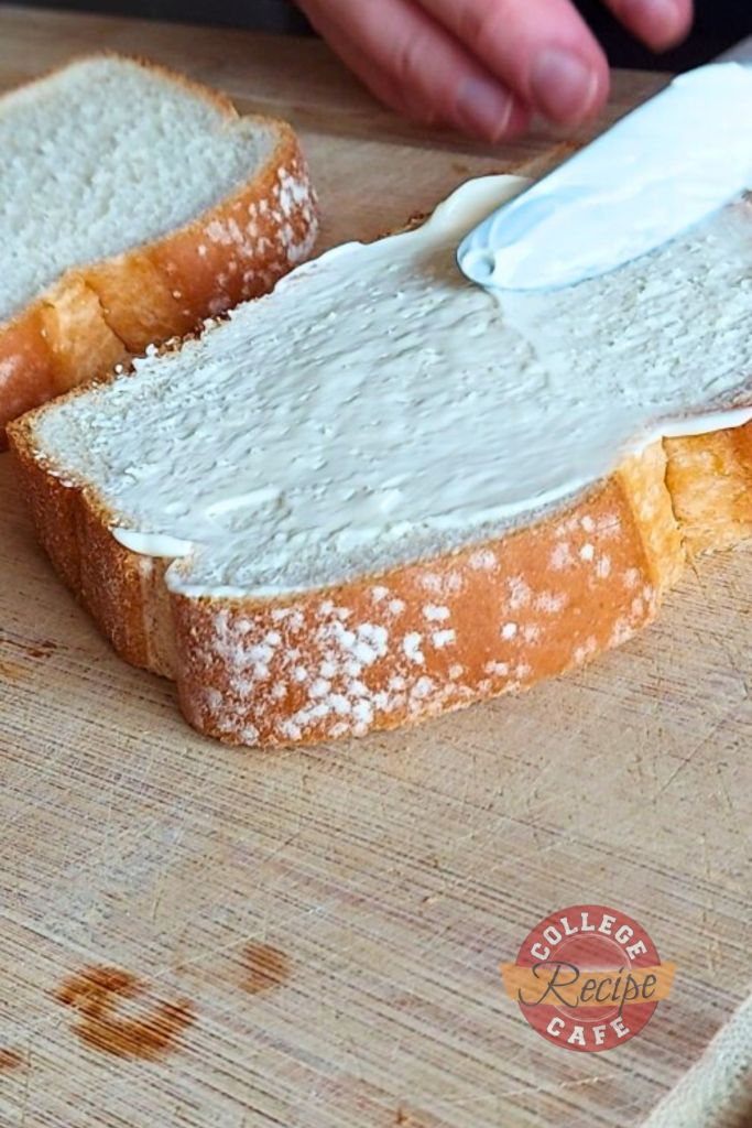 Spreading mayo over a slice of bread